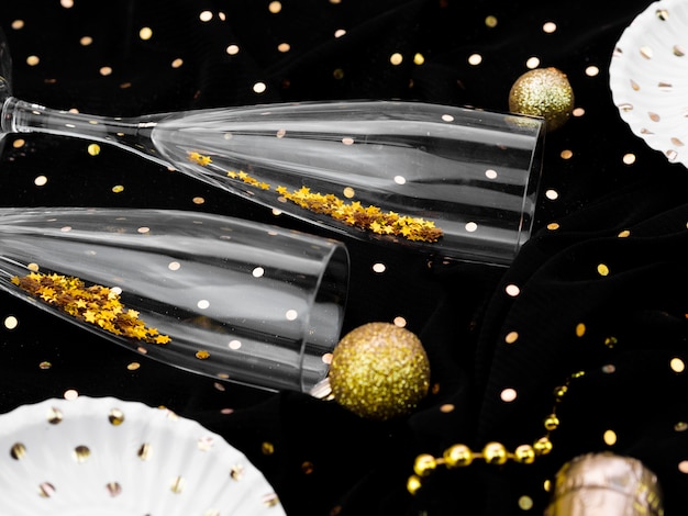 Бесплатное фото Плоская планировка бокалов с блеском для новогодней вечеринки
