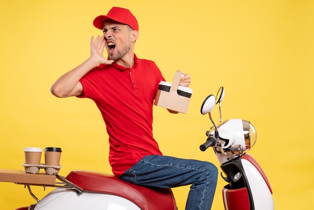 Free photo front view male courier in red uniform with coffee on yellow uniform bike color work worker service job