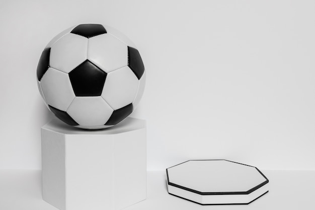 Бесплатное фото Вид спереди нового футбольного мяча на пьедестале с копией пространства