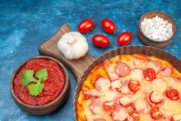 Free photo front view delicious cheese pizza with sausages and tomatoes on blue italian food dough cake fast-food photo color