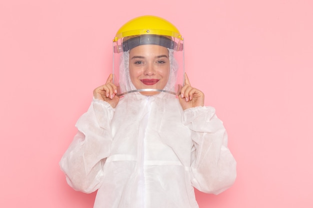 Free photo front view young beautiful female in special white suit wearing special yellow helmet and smiling on the pink space special suit  girl woman
