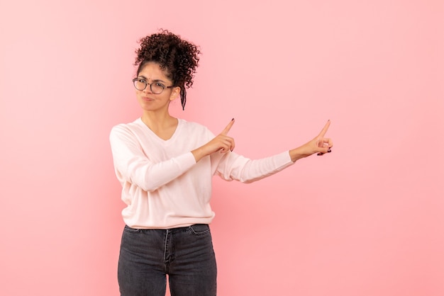 Free photo front view of young woman displeased on a pink wall