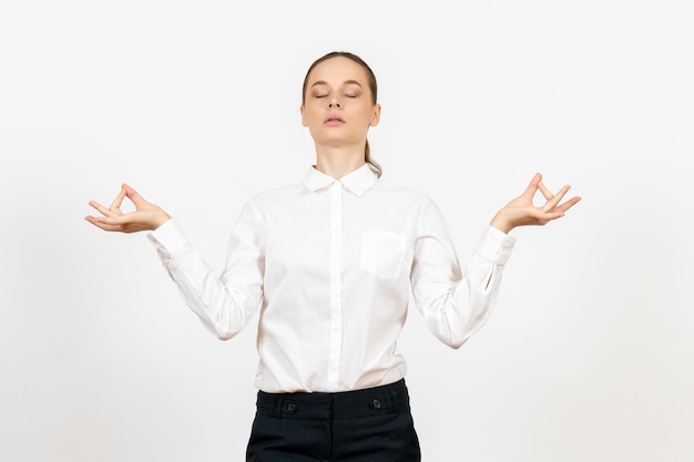 Бесплатное фото Вид спереди молодая женщина в белой блузке с лицом медитации на белом фоне работа офис женские эмоции чувство модели