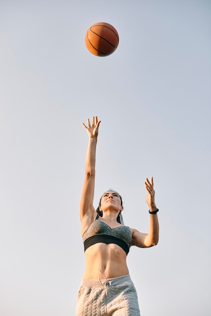 Foto gratuita giovane donna di vista frontale che gioca pallacanestro da solo