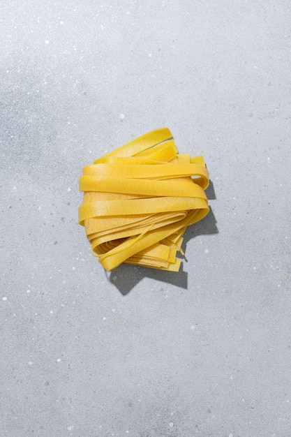 Free photo fresh italian pasta papardelle with flour on bright background top view