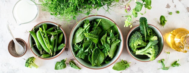 Foto gratuita spinaci freschi, foglie di pisello verde, broccoli in una ciotola, vista dall'alto