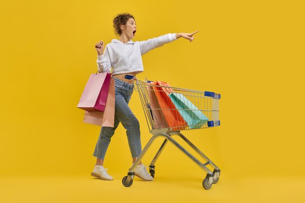 Girl with standing with packages and cart screaming