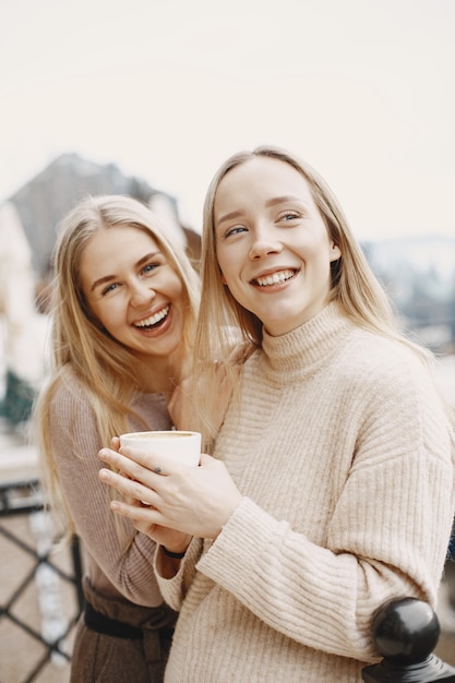 Бесплатное фото Девушки в легкой одежде. зимний кофе на балконе. счастливые женщины вместе.