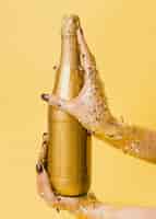 Бесплатное фото Золотая бутылка шампанского в руках