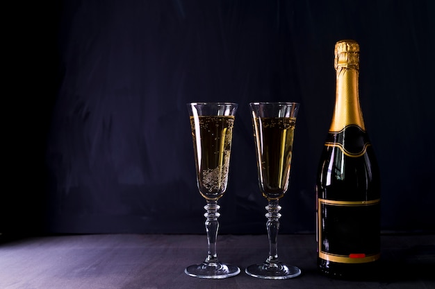 Бесплатное фото Бокалы шампанского с бутылкой на столе