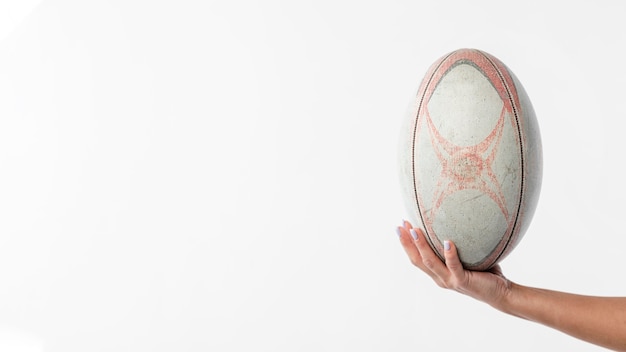 Hand holding rugby ball with copy space