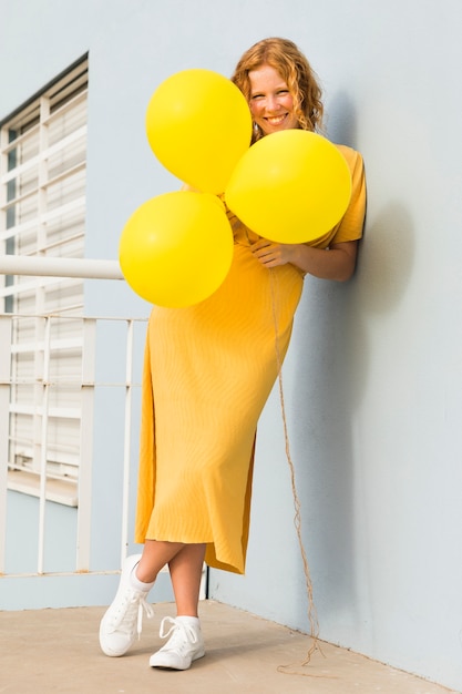 Бесплатное фото Счастливая женщина держит воздушные шары