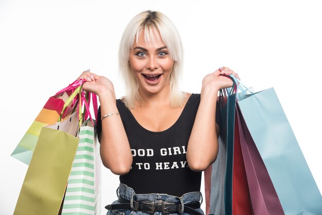 Happy young woman holding shopping bags on white background. High quality photo