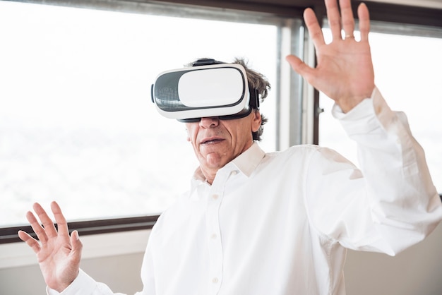 Free photo happy man exploring virtual reality headset simulation