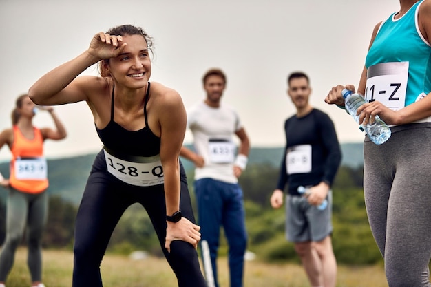 Бесплатное фото Счастливая спортсменка чувствует себя измотанной после марафона на природе