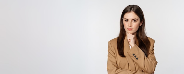 Free photo image of businesswoman thinking corporate woman looking thoughtful making decision standing in brown