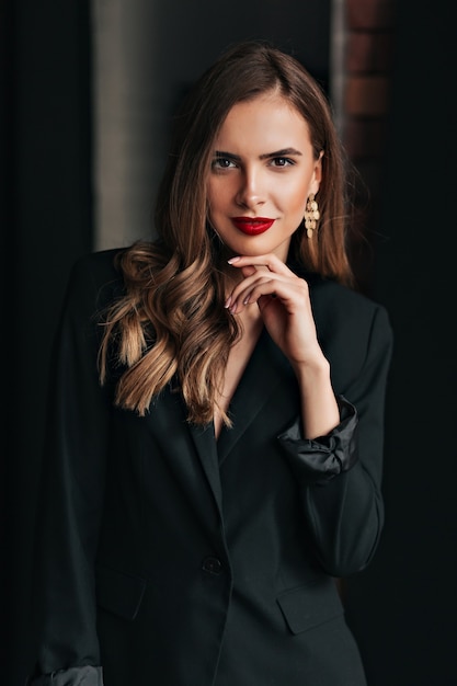 Free photo indoor studio shot of attractive pretty woman with light-brown hair wearing black jacket with red lips