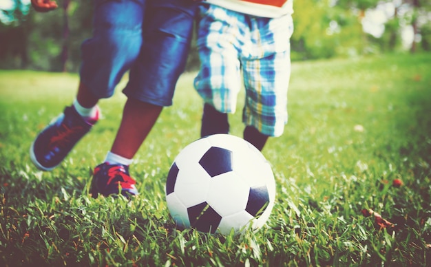 Дети играют в футбол на траве