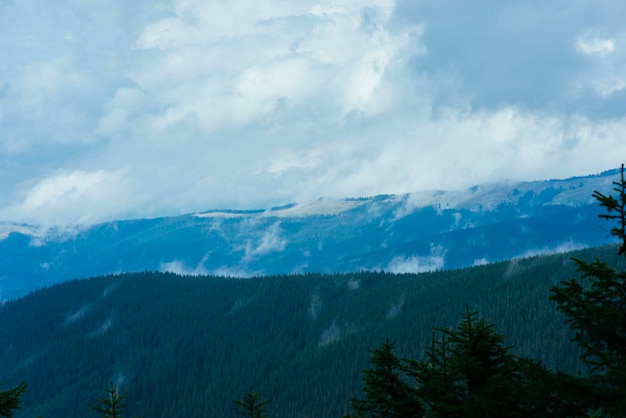 Бесплатное фото Пейзаж слоистой горы в тумане голубое небо с облаками