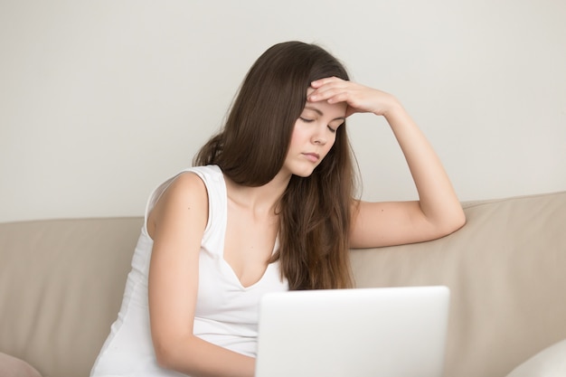 Lady suffering from headache after work on laptop