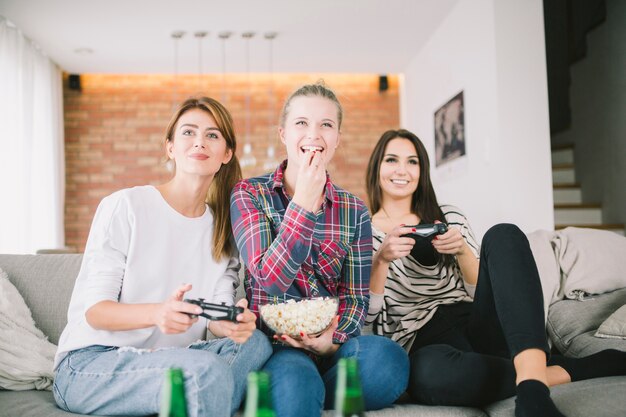 Free photo laughing girlfriends playing videogame and having party