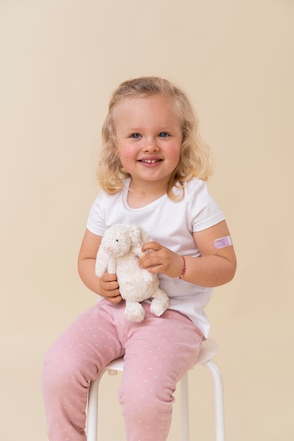 Бесплатное фото Маленькая девочка держит игрушку после вакцинации