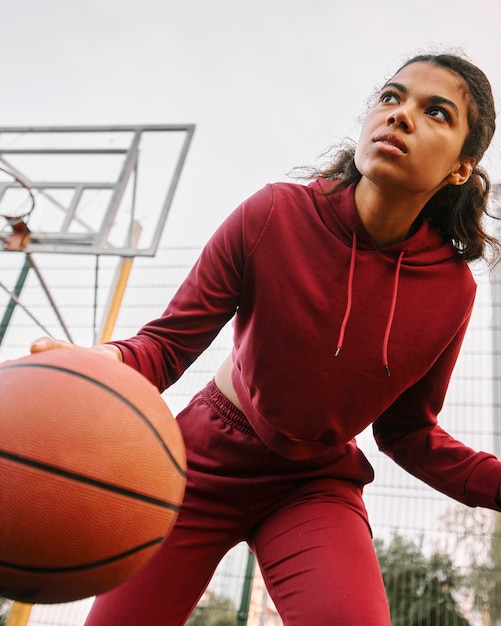 Бесплатное фото Женщина с низким углом играет в баскетбол
