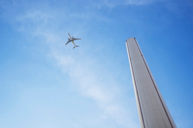 Free photo low angle tall chimney and airplane