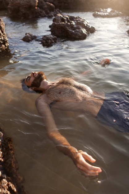 Мужчина с волосатой грудью на берегу моря