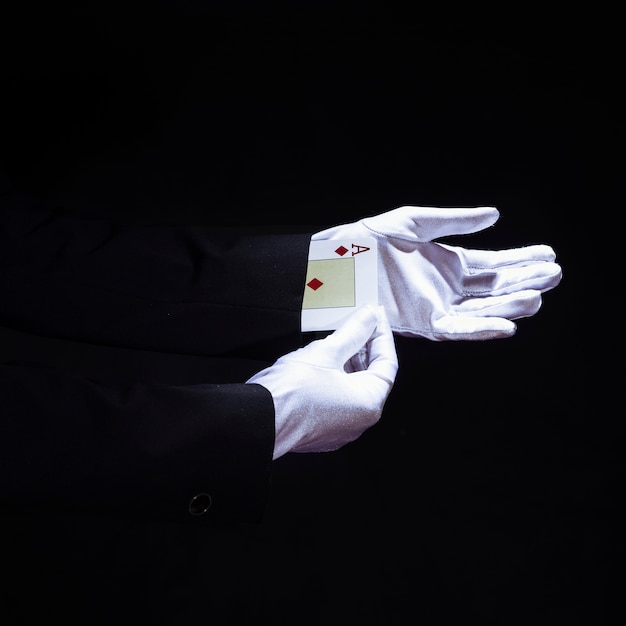 Маг, удаляющий тузы, играющие в карты с руки на черном фоне