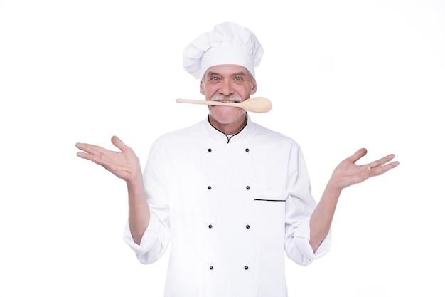 Free photo male chef in uniform holding wooden spoon on mouse while staying on white wall