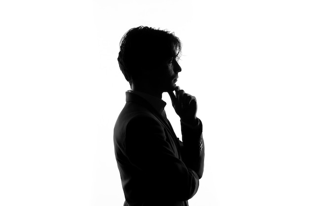 Бесплатное фото Силуэт мужчины в строгом костюме, думающий, вид сбоку, тень, освещенная белым фоном