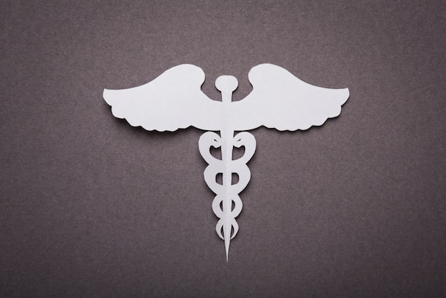 Free photo medical background, paper cut of caduceus medical symbol with co