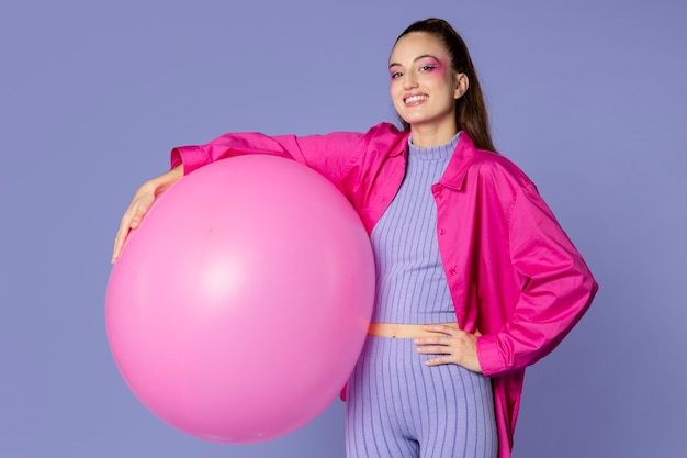 Бесплатное фото Женщина среднего роста с розовым шариком