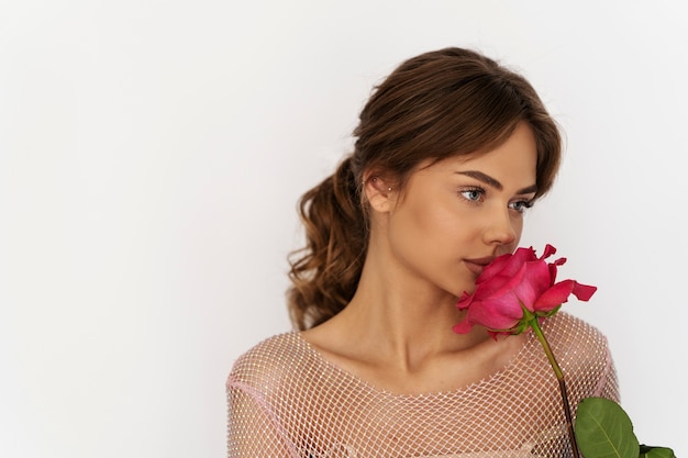 Бесплатное фото Женщина среднего роста позирует с цветком