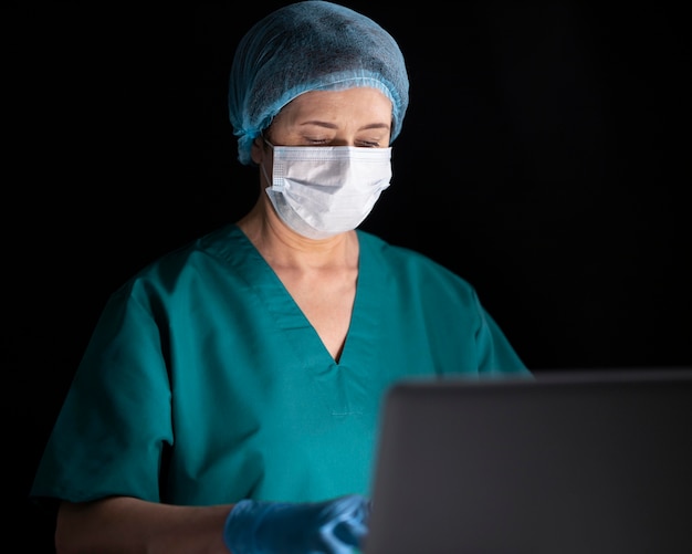 Medium shot doctor with laptop and face mask