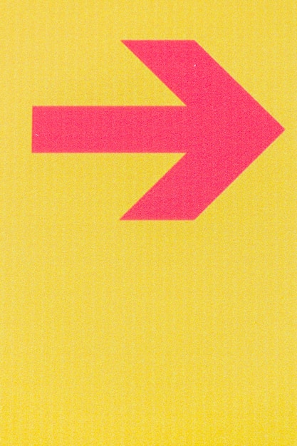 Бесплатное фото Минималистская красная стрелка на желтом фоне и копией пространства