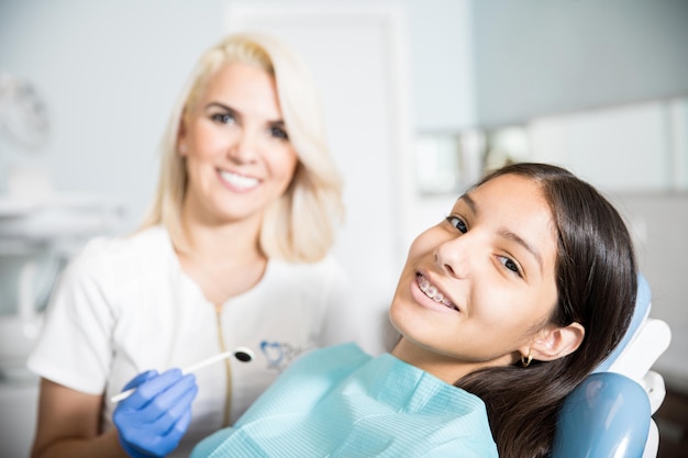 Free photo mid adult dentist with patient at dental clinic