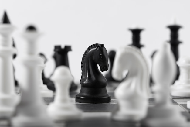 Бесплатное фото Монохромные шахматные фигуры с игровой доской