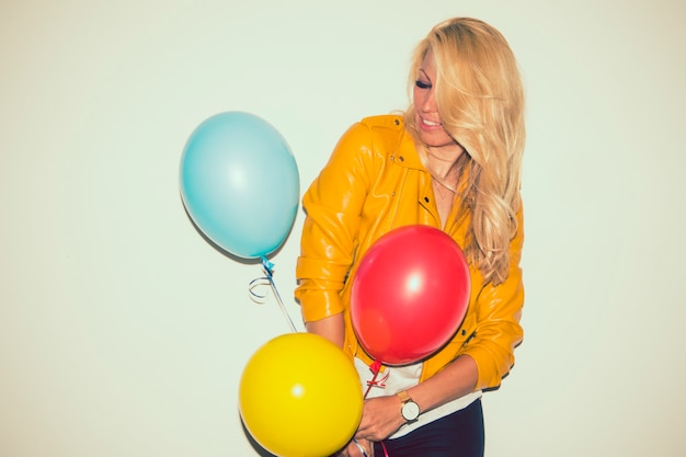 Бесплатное фото Современная блондинка с воздушными шарами и смешной позой