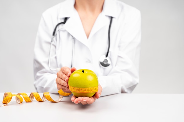 Free photo nutritionist woman holding an apple