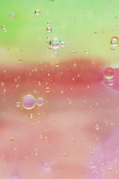 Foto gratuita l'olio cade in acqua su sfondo colorato