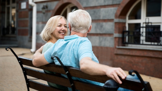 Бесплатное фото Пожилая пара наслаждается временем на скамейке на открытом воздухе