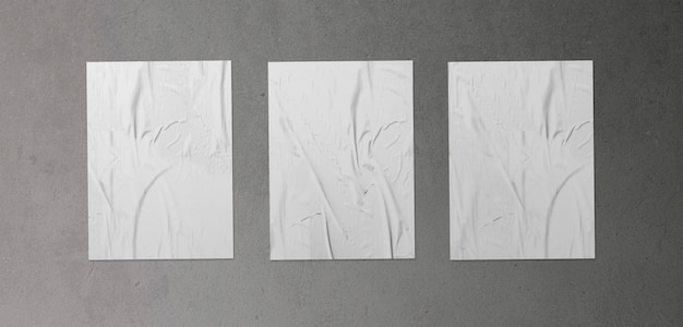 Free photo pack of three crumpled posters on concrete surface