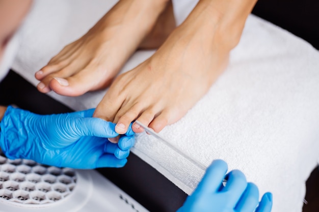 Pedicure process Home salon pedicure Foot care treatment and nail The process of professional pedicures Master in blue gloves make pedicure