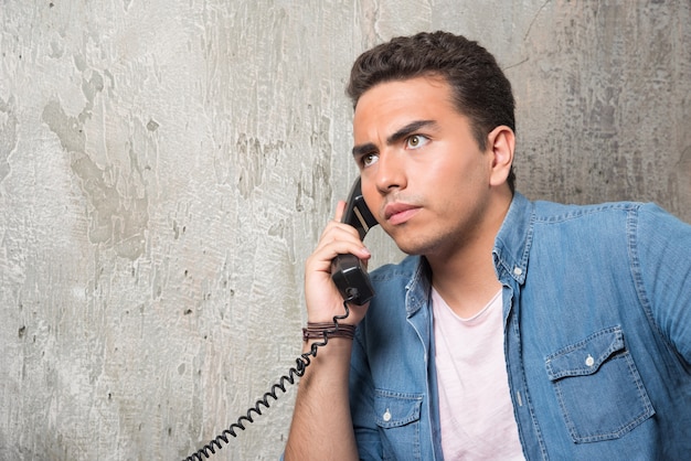 Free photo photo of young man talking on phone and sitting on chair . high quality photo