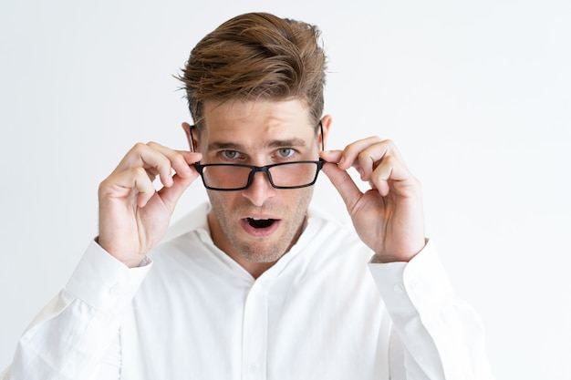 Free photo portrait of young businessman in glasses looking in surprise