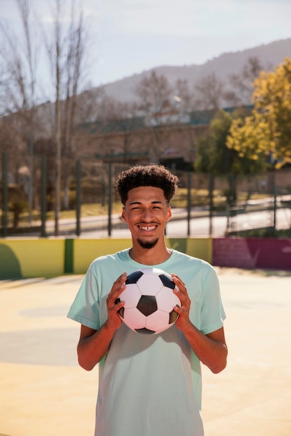 Portrait young man with football ball