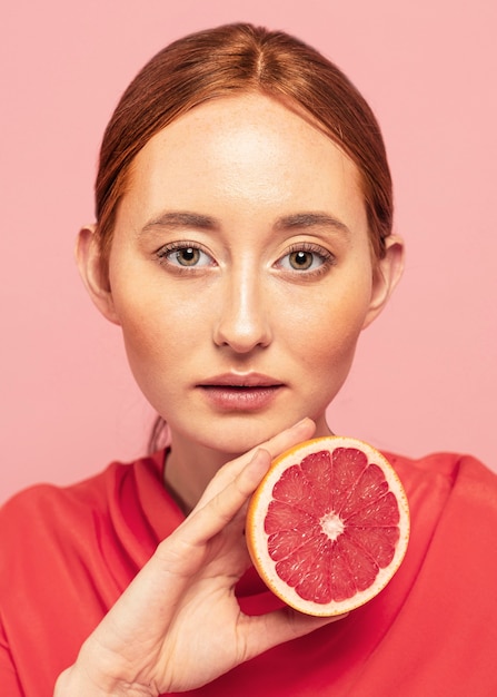 Portrait of beautiful woman holding a fruit