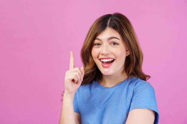 Free photo portrait of excited young woman wearing casual tshirt thinking and imagination isolated over pink background